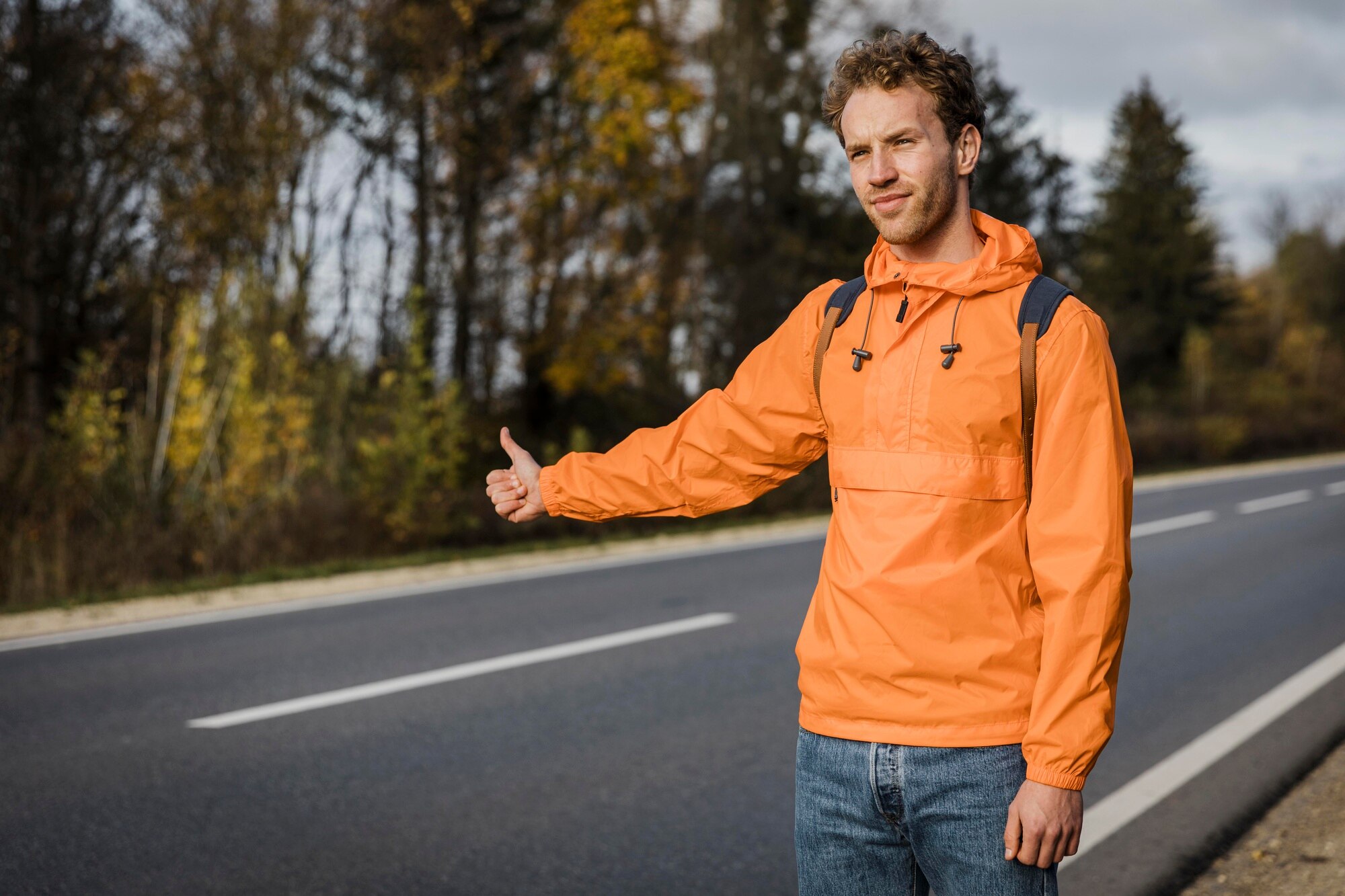 Pria berjalan di jalanan berkabut dengan jaket tebal